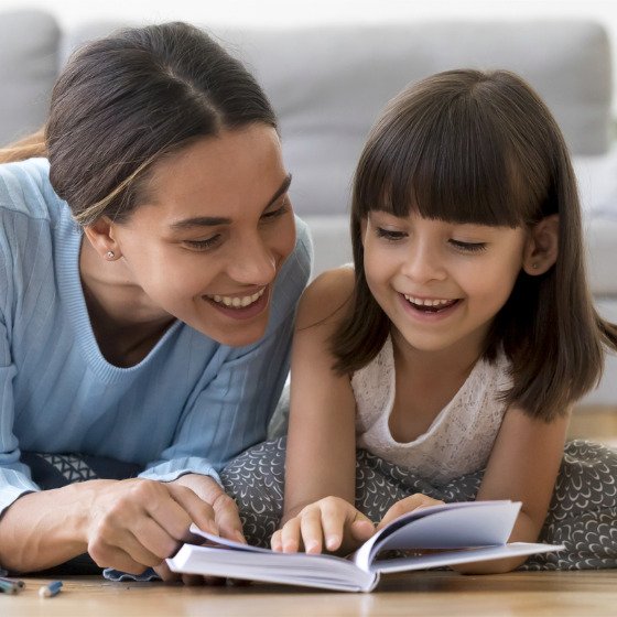 mother-and-daughter-lying-on-warm-floor-reading-book-picture