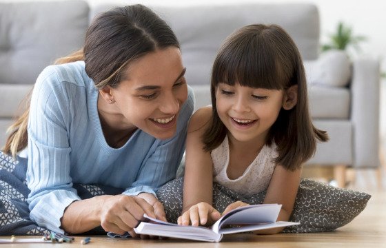 mother-and-daughter-lying-on-warm-floor-reading-book-picture
